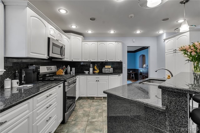 66 Devonshire Rd, Tonawanda, NY 14223 - kitchen with stainless steel appliances, backsplash, white cabinets, recessed lighting, and dark stone counters