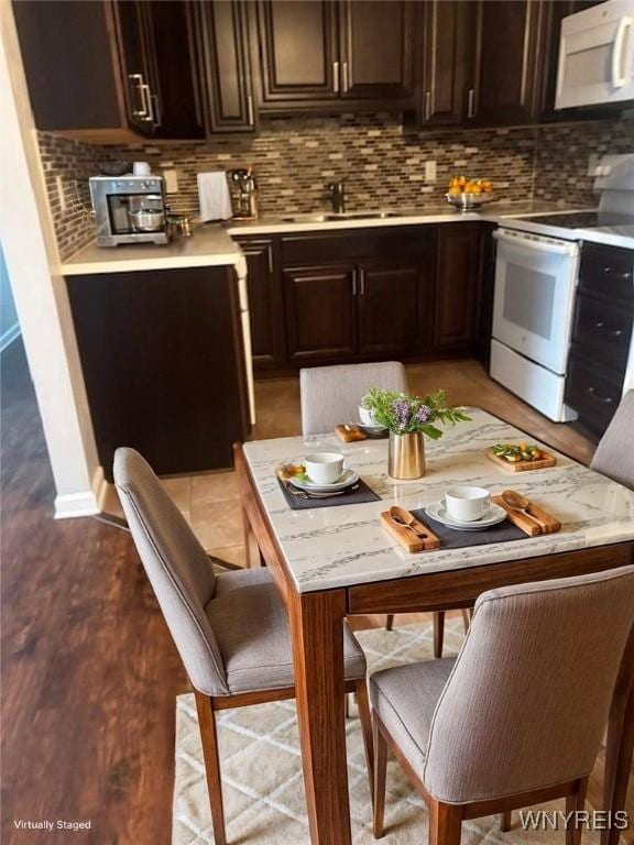 770 W Ferry St Unit 9A, Buffalo, NY 14222 - kitchen with white appliances, light countertops, tasteful backsplash, and dark brown cabinets