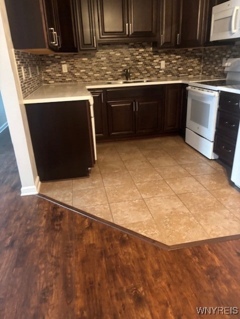770 W Ferry St Unit 9A, Buffalo, NY 14222 - kitchen featuring white appliances, light countertops, tasteful backsplash, light wood-type flooring, and dark brown cabinetry