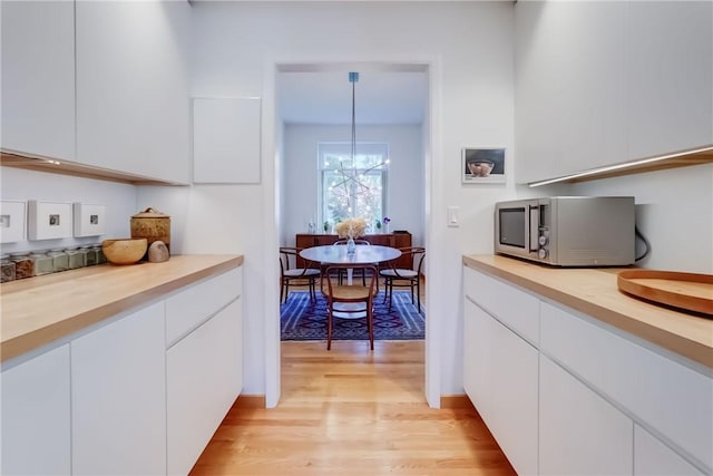 56 Waterview Cir, Penfield, NY 14625 - kitchen featuring stainless steel microwave, light wood-type flooring, white cabinetry, and a chandelier