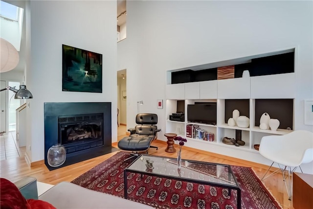 56 Waterview Cir, Penfield, NY 14625 - living room featuring wood finished floors, a fireplace with flush hearth, and a towering ceiling