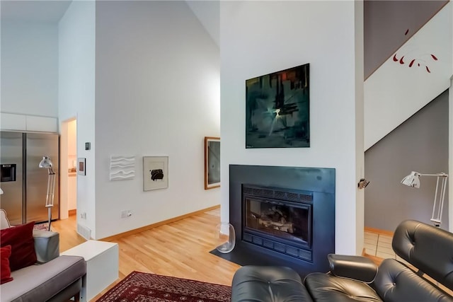 56 Waterview Cir, Penfield, NY 14625 - living room with a high ceiling, a fireplace with flush hearth, and light wood-style floors