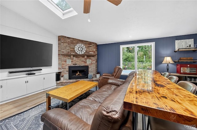 5647 Stevens Dr S, Cicero, NY 13039 - living room with wood finished floors, ceiling fan, a skylight, lofted ceiling, and a brick fireplace