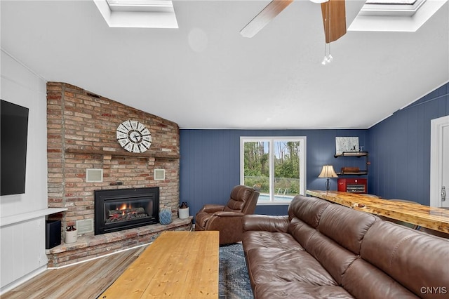 5647 Stevens Dr S, Cicero, NY 13039 - living room with wood finished floors, a fireplace, vaulted ceiling, ceiling fan, and a skylight