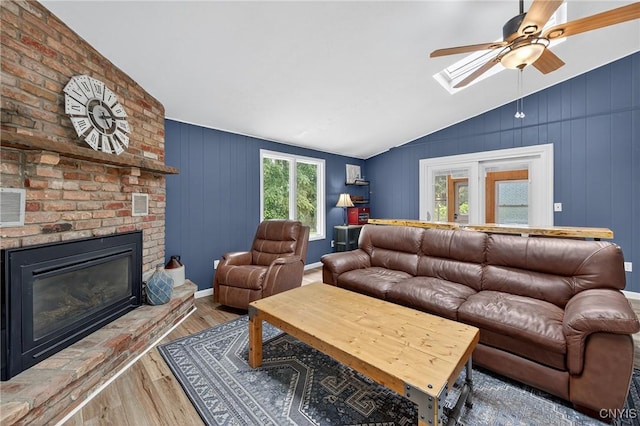 5647 Stevens Dr S, Cicero, NY 13039 - living room featuring lofted ceiling, wood finished floors, ceiling fan, a skylight, and a brick fireplace