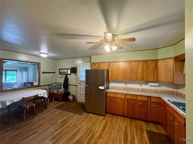 16 Locust Ave, Cortland, NY 13045 - kitchen featuring freestanding refrigerator, brown cabinetry, light wood-style flooring, and a ceiling fan