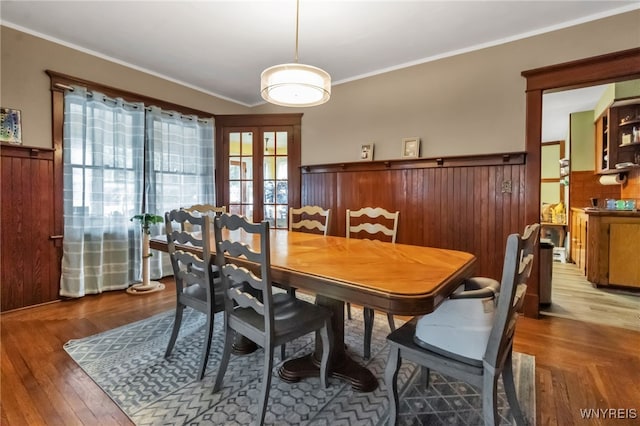 6467 Patchin Rd, Boston, NY 14025 - dining space featuring a wainscoted wall, ornamental molding, french doors, wood finished floors, and wooden walls