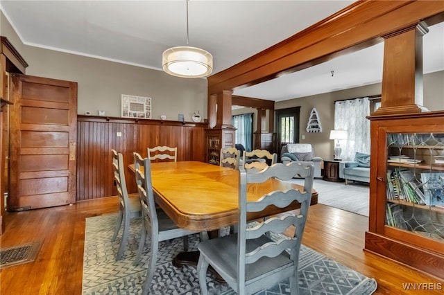 6467 Patchin Rd, Boston, NY 14025 - dining room featuring ornate columns, wood finished floors, and wainscoting
