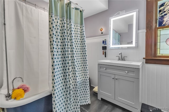 6467 Patchin Rd, Boston, NY 14025 - full bath featuring wainscoting, vanity, a shower with shower curtain, wood finished floors, and a decorative wall