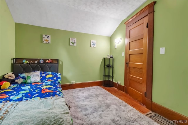 6467 Patchin Rd, Boston, NY 14025 - bedroom with vaulted ceiling, wood finished floors, and a textured ceiling