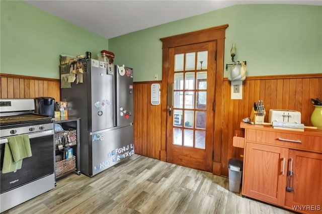6467 Patchin Rd, Boston, NY 14025 - kitchen featuring stainless steel appliances, wainscoting, light wood-type flooring, wooden walls, and brown cabinetry
