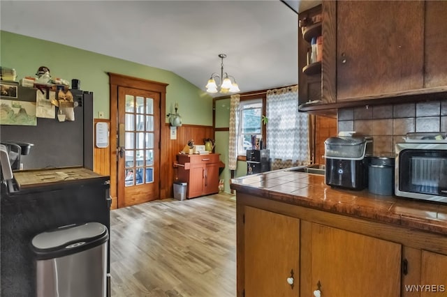 6467 Patchin Rd, Boston, NY 14025 - kitchen with light wood finished floors, lofted ceiling, a wainscoted wall, a chandelier, and refrigerator