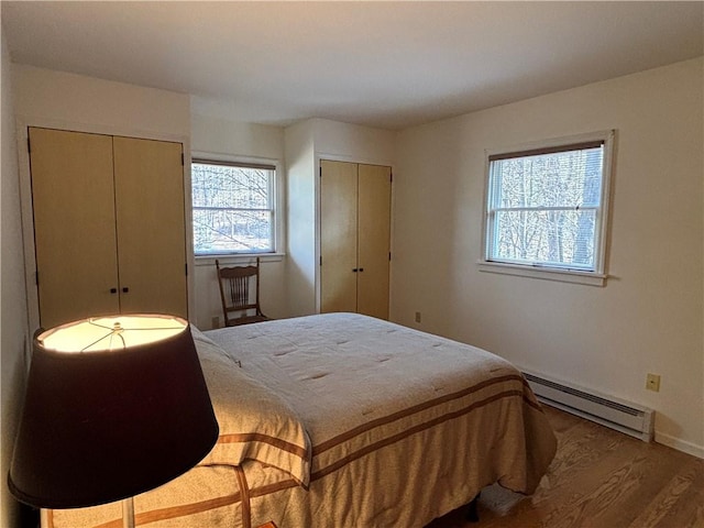 1237 County Highway 11, Davenport, NY 13860 - bedroom with a baseboard heating unit, two closets, multiple windows, and wood finished floors
