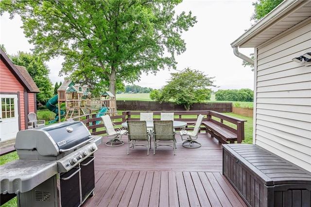 25 Killdeer Ln, Perinton, NY 14450 - wooden deck with grilling area, outdoor dining space, a playground, and a fenced backyard