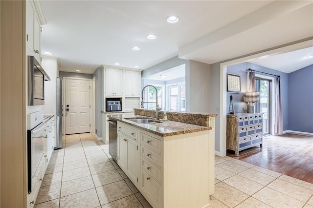 25 Killdeer Ln, Perinton, NY 14450 - kitchen with appliances with stainless steel finishes, light tile patterned flooring, an island with sink, light stone counters, and plenty of natural light