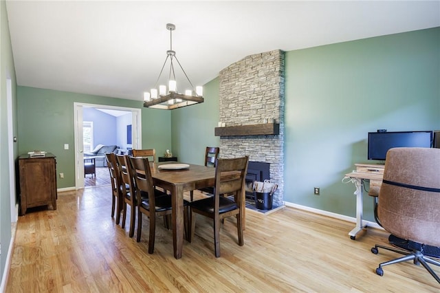 25 Killdeer Ln, Perinton, NY 14450 - dining room featuring a chandelier, light wood-type flooring, vaulted ceiling, and a fireplace