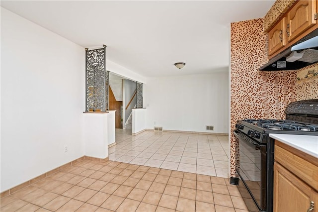 24 Gray St, Rochester, NY 14609 - kitchen with black range with gas cooktop, light tile patterned floors, under cabinet range hood, tasteful backsplash, and light countertops