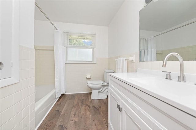 24 Gray St, Rochester, NY 14609 - full bath featuring tile walls, vanity, wood finished floors, shower / bath combo with shower curtain, and wainscoting
