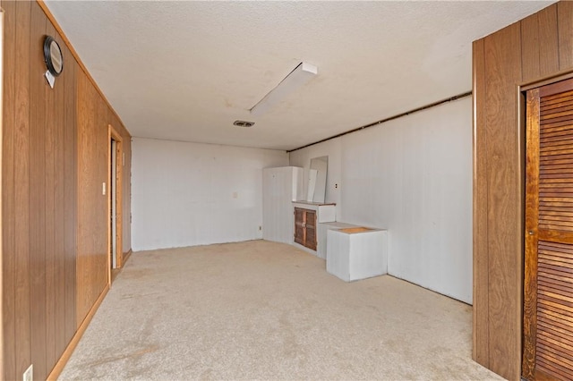 24 Gray St, Rochester, NY 14609 - unfurnished room featuring light carpet, wood walls, and a textured ceiling