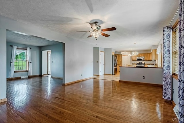 121 Ben Bar Cir, Whitestown, NY 13492 - unfurnished living room with ceiling fan, a chandelier, light wood finished floors, and a textured ceiling