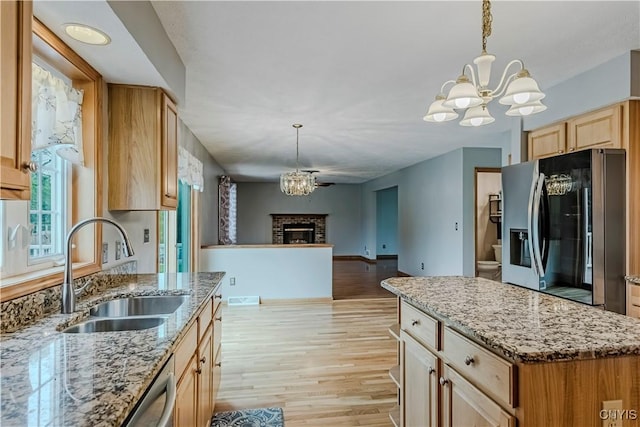 121 Ben Bar Cir, Whitestown, NY 13492 - kitchen featuring stainless steel appliances, a chandelier, a brick fireplace, and light wood-style floors