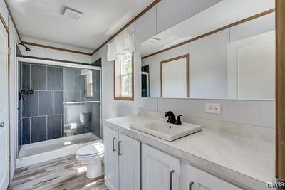 27634 County Route 342, Le Ray, NY 13612 - full bath with vanity, wood finished floors, and enclosed tub / shower combo