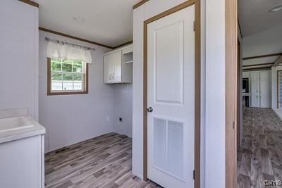 27634 County Route 342, Le Ray, NY 13612 - washroom featuring cabinet space and light wood-type flooring