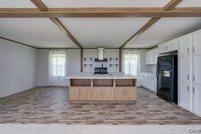 27634 County Route 342, Le Ray, NY 13612 - kitchen featuring freestanding refrigerator, light wood-type flooring, white cabinets, ventilation hood, and light countertops