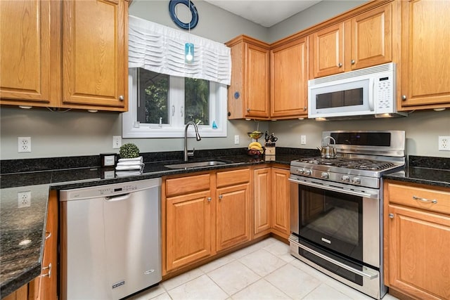 228 Southshore Pl, Webster, NY 14580 - kitchen with appliances with stainless steel finishes, light tile patterned floors, dark stone countertops, and brown cabinets
