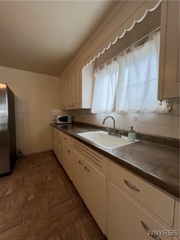 2479 Forest Ave, Niagara Falls, NY 14301 - kitchen featuring freestanding refrigerator, dark countertops, decorative backsplash, and white cabinets