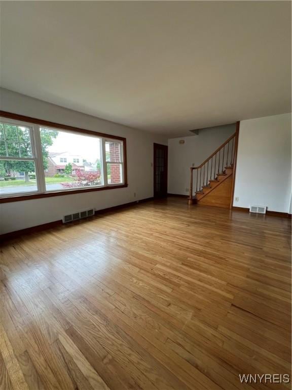 2479 Forest Ave, Niagara Falls, NY 14301 - unfurnished living room featuring light wood-style floors and stairs