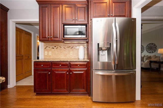 9 Rolling Woods Ln Unit E, West Seneca, NY 14224 - kitchen featuring stainless steel refrigerator with ice dispenser, dark brown cabinets, tasteful backsplash, light wood finished floors, and light stone counters