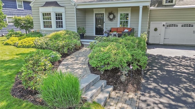 200 Halton Rd, Dewitt, NY 13224 - doorway to property with asphalt driveway, a garage, a porch, and a shingled roof