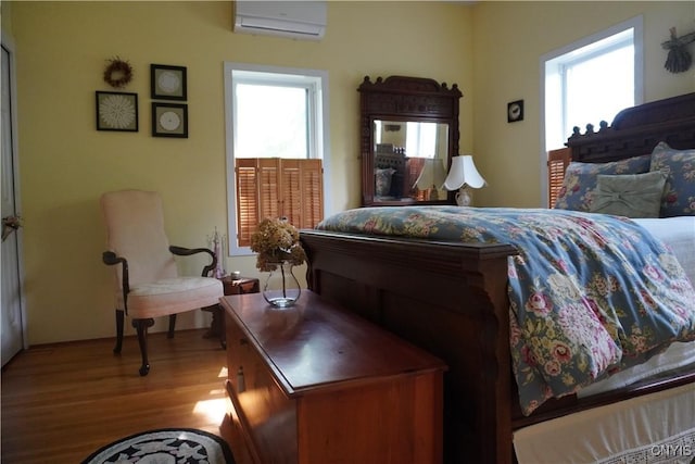 64 Bunner St, Oswego, NY 13126 - bedroom with an AC wall unit, multiple windows, and wood finished floors