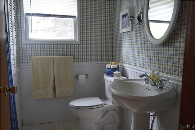 64 Bunner St, Oswego, NY 13126 - bathroom featuring wallpapered walls and a wainscoted wall