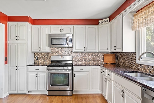 5 Tudor Dr, Owego, NY 13760 - kitchen featuring appliances with stainless steel finishes, dark stone countertops, white cabinetry, and light wood finished floors