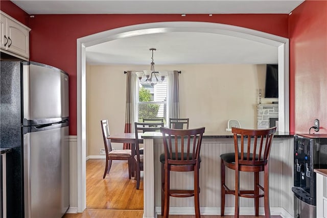 5 Tudor Dr, Owego, NY 13760 - dining room with light wood-style floors, arched walkways, and a chandelier