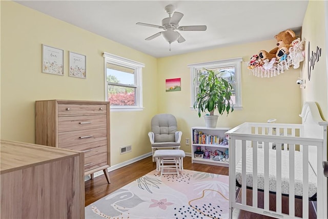 5 Tudor Dr, Owego, NY 13760 - bedroom featuring multiple windows, wood finished floors, a crib, and a ceiling fan