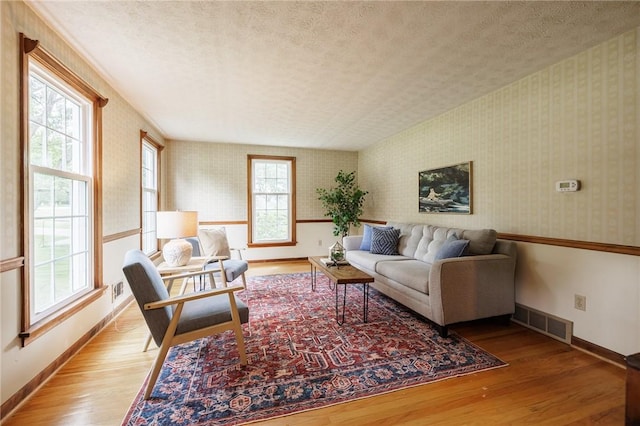 326 Cheese Factory Rd, Mendon, NY 14472 - living area featuring wallpapered walls, plenty of natural light, a textured ceiling, and light wood-style flooring