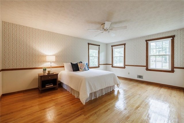 326 Cheese Factory Rd, Mendon, NY 14472 - bedroom with wallpapered walls, light wood finished floors, and a ceiling fan