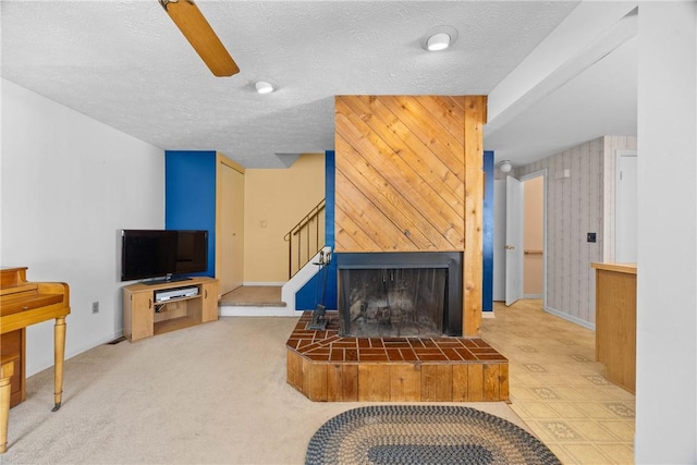 1521 Aster Ter, Walworth, NY 14568 - living area with a textured ceiling, a ceiling fan, a fireplace, stairway, and carpet flooring