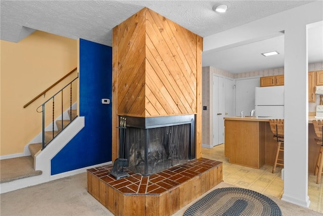 1521 Aster Ter, Walworth, NY 14568 - detailed view of freestanding refrigerator, a textured ceiling, range hood, carpet floors, and a tiled fireplace