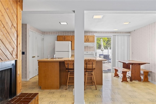 1521 Aster Ter, Walworth, NY 14568 - kitchen with freestanding refrigerator, stove, wallpapered walls, under cabinet range hood, and a kitchen island