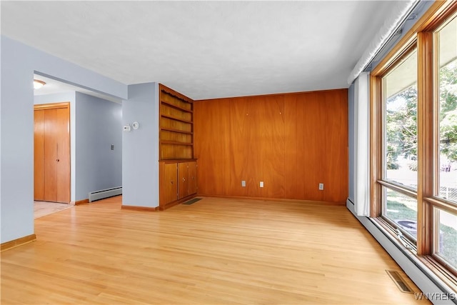 566 Adam St, Tonawanda, NY 14150 - spare room featuring a baseboard heating unit and light wood-type flooring