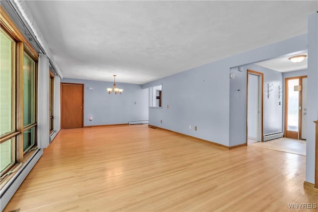 566 Adam St, Tonawanda, NY 14150 - spare room featuring a baseboard radiator, a chandelier, and light wood-type flooring