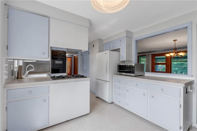 566 Adam St, Tonawanda, NY 14150 - kitchen featuring appliances with stainless steel finishes, a chandelier, light countertops, and decorative backsplash