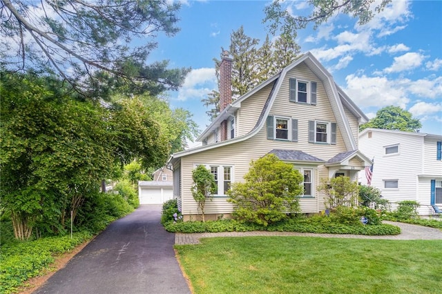 23 Hathaway Rd, Irondequoit, NY 14617 - colonial inspired home featuring a front lawn, a chimney, a gambrel roof, an outdoor structure, and a detached garage