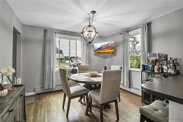 3029 Stieg Rd, Wheatfield, NY 14120 - dining area with baseboard heating, a chandelier, and wood finished floors