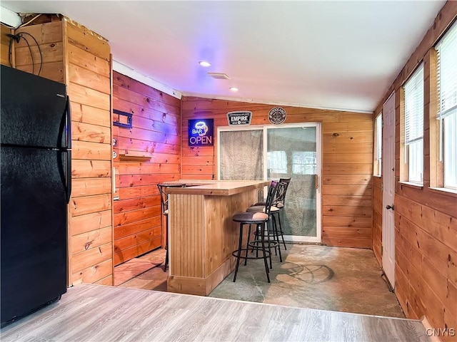 9 Curtis Ave, Lysander, NY 13027 - indoor dry bar with freestanding refrigerator, lofted ceiling, wooden walls, and light wood finished floors