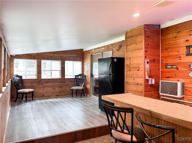 9 Curtis Ave, Lysander, NY 13027 - kitchen featuring freestanding refrigerator, wood walls, lofted ceiling, wood finished floors, and light countertops